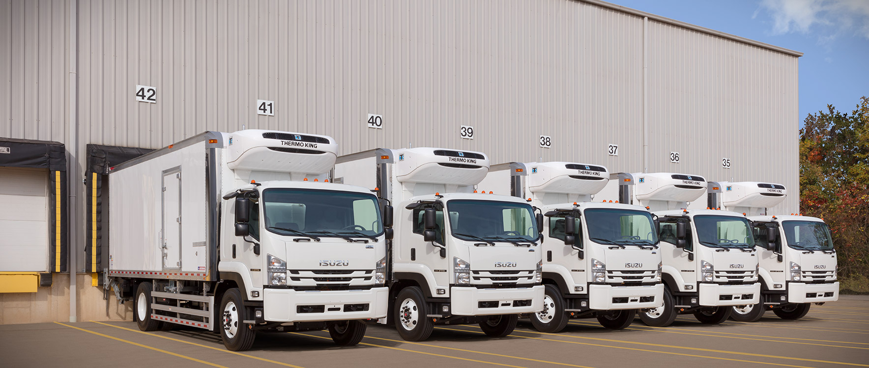 A fleet of Refrigerated Cold Star truck bodies at a loading dock